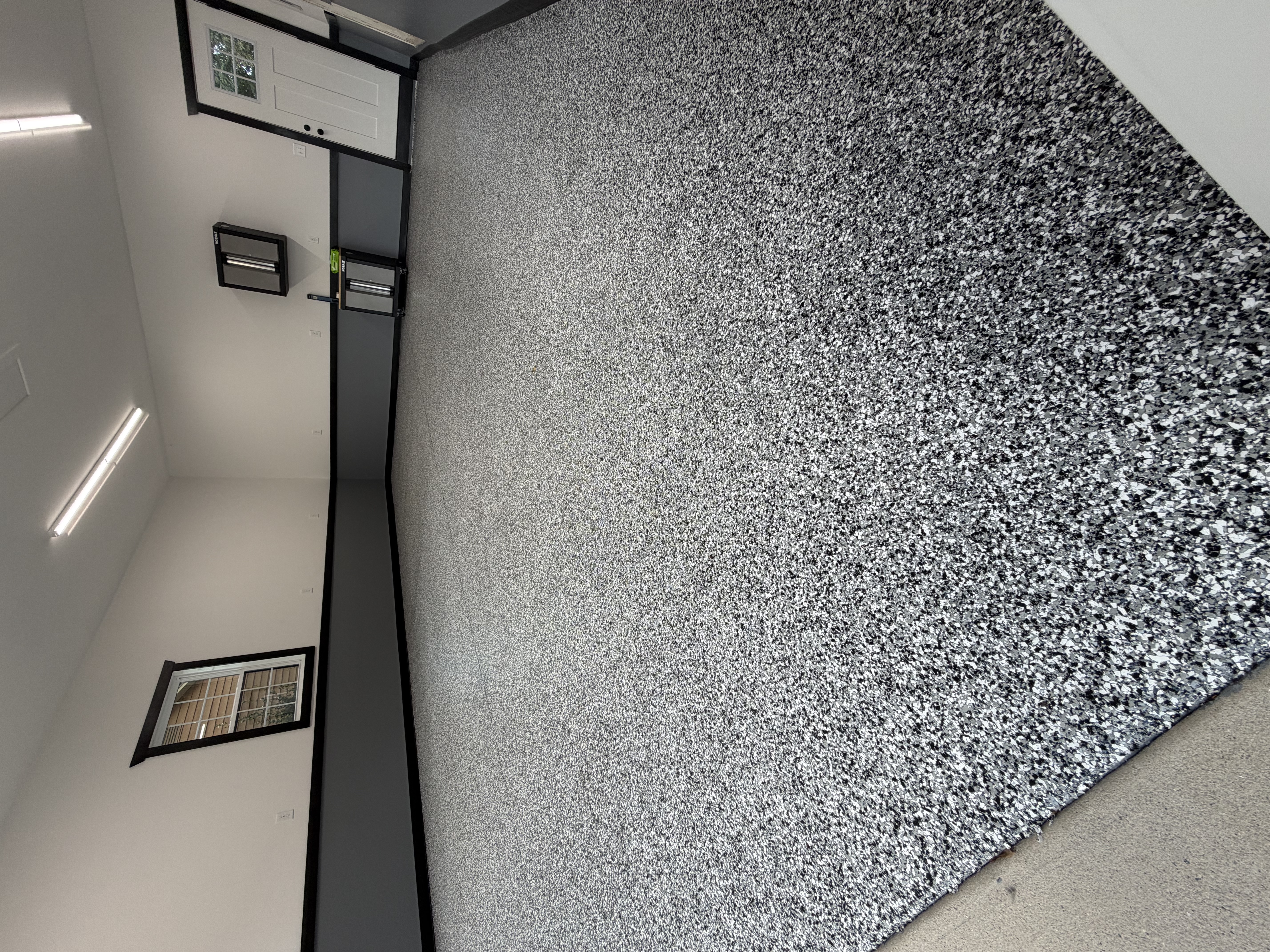 Sunlit garage with finished flooring and an open door